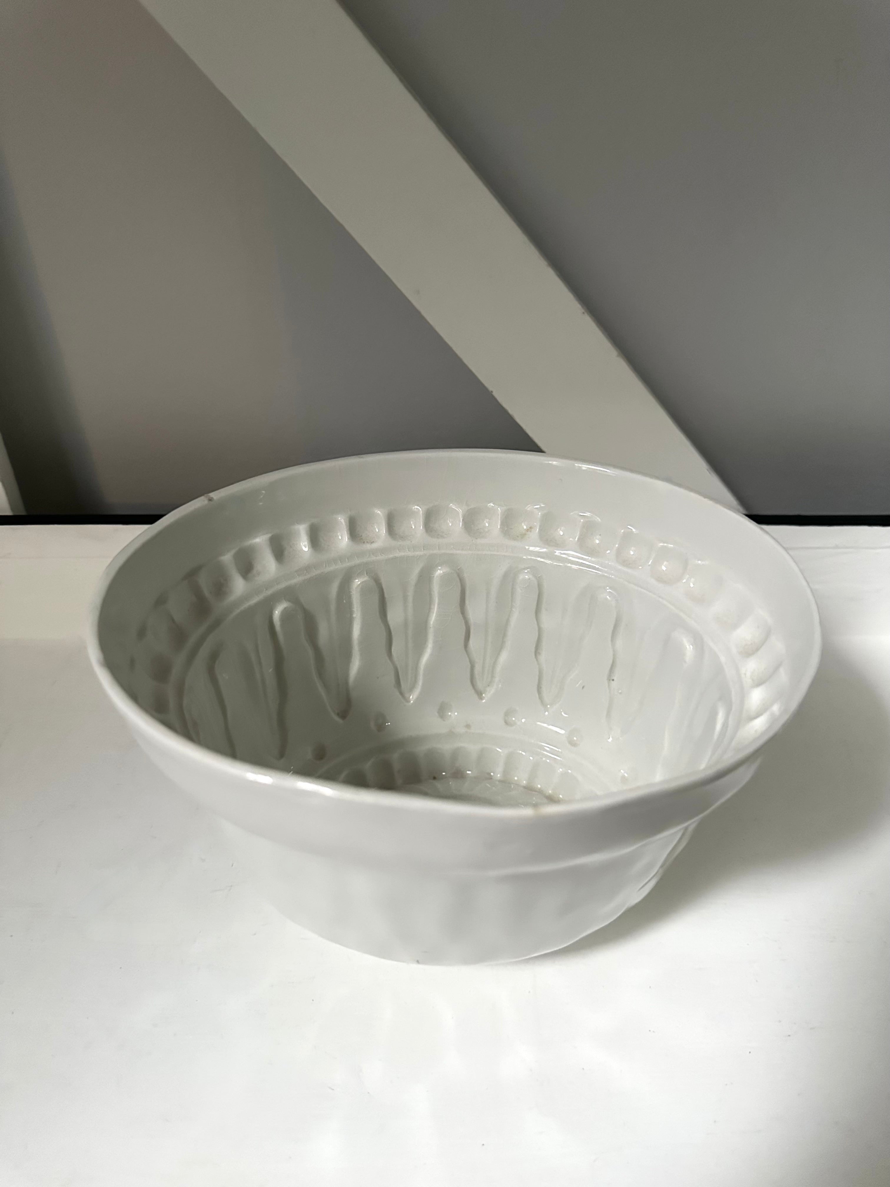 White ceramic bowl with textured design on a white surface