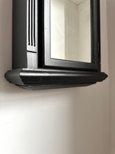 Black framed wall unit mounted on a wall