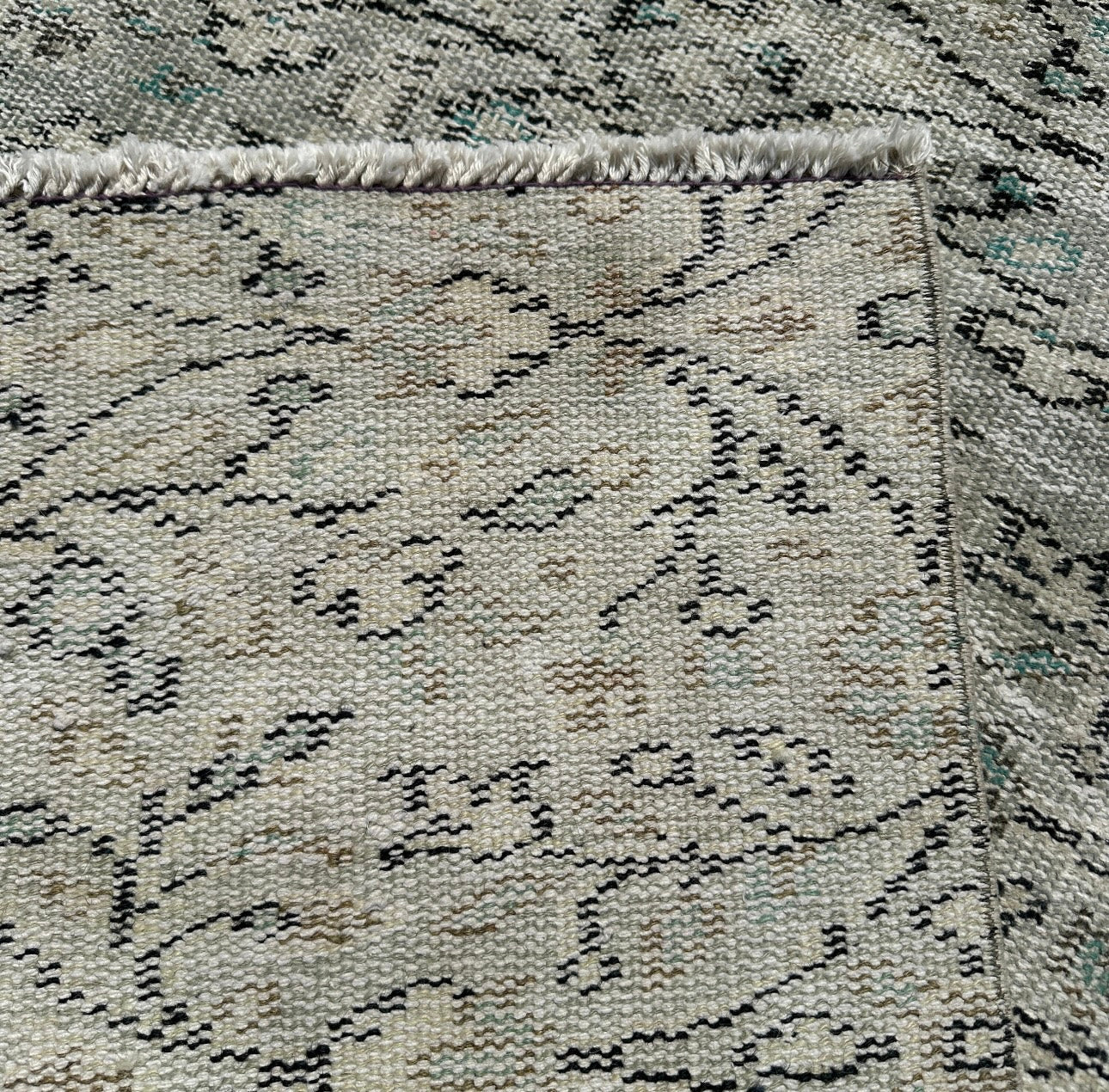 Close-up of a textured gray rug with black pattern