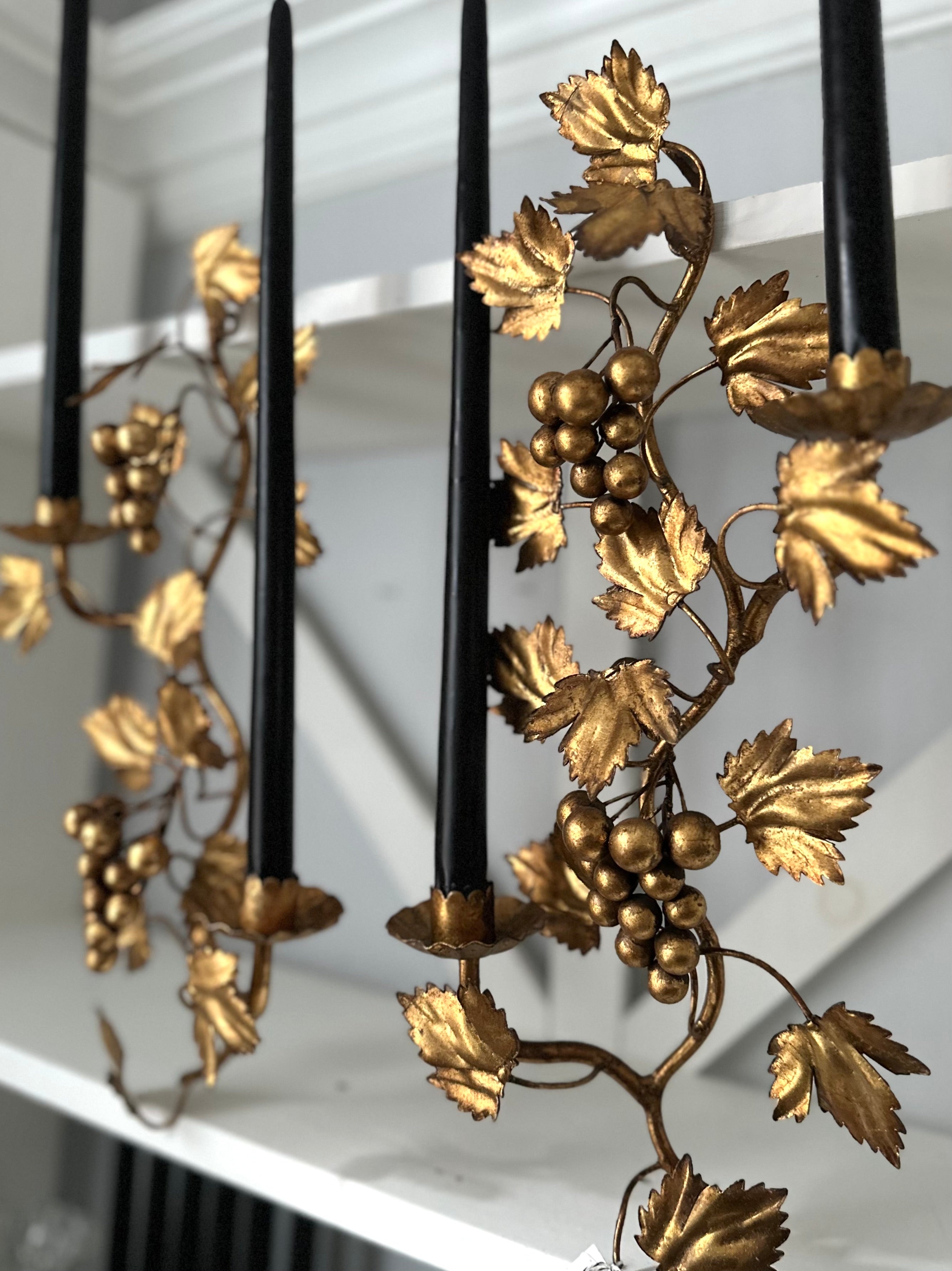 Decorative candle holder with gold leaf and grape design on a white surface