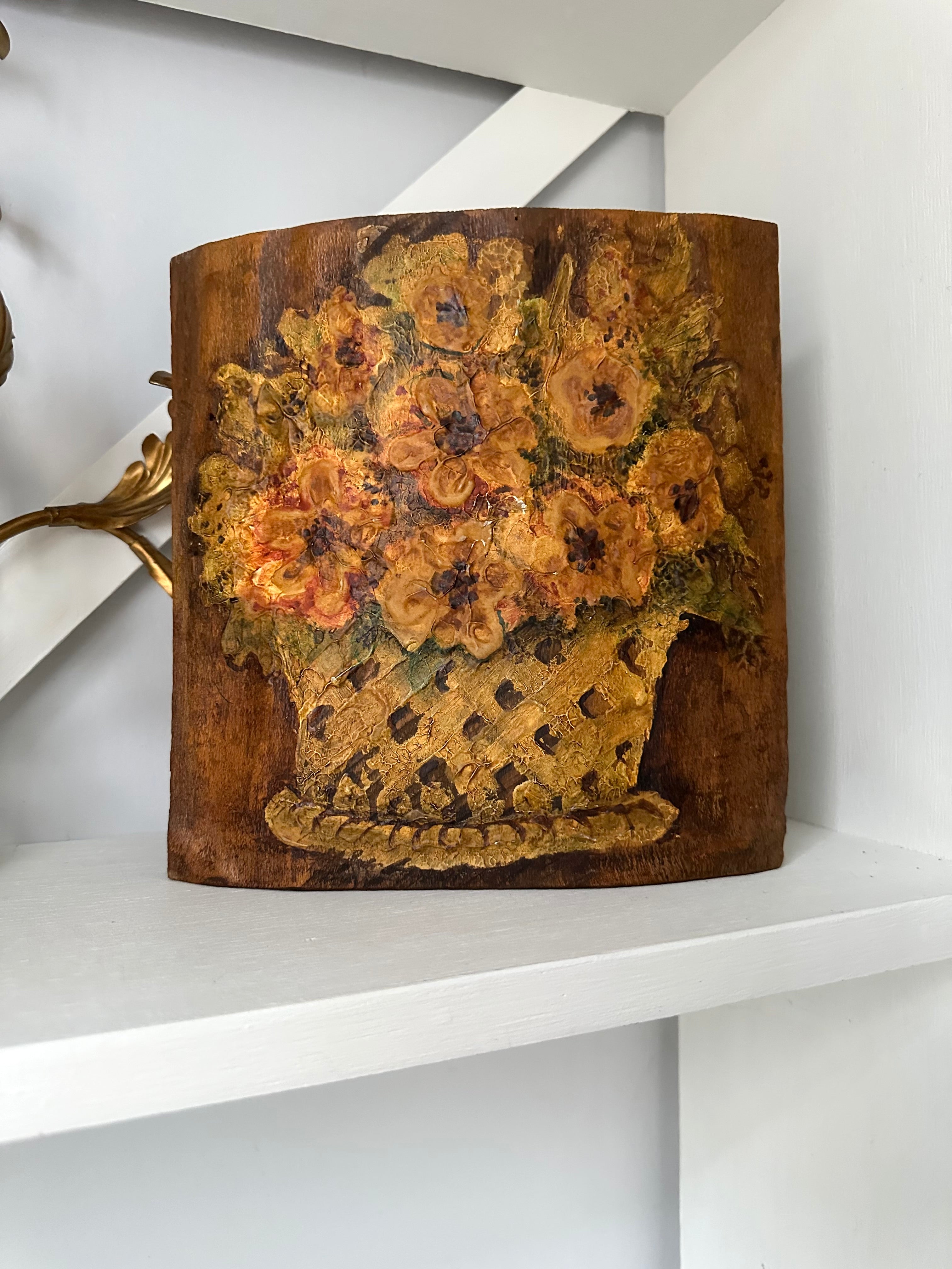 Decorative wooden basket with floral design on a white shelf