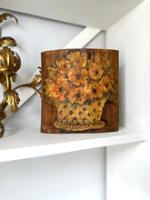 Decorative wooden art with floral design on a white shelf
