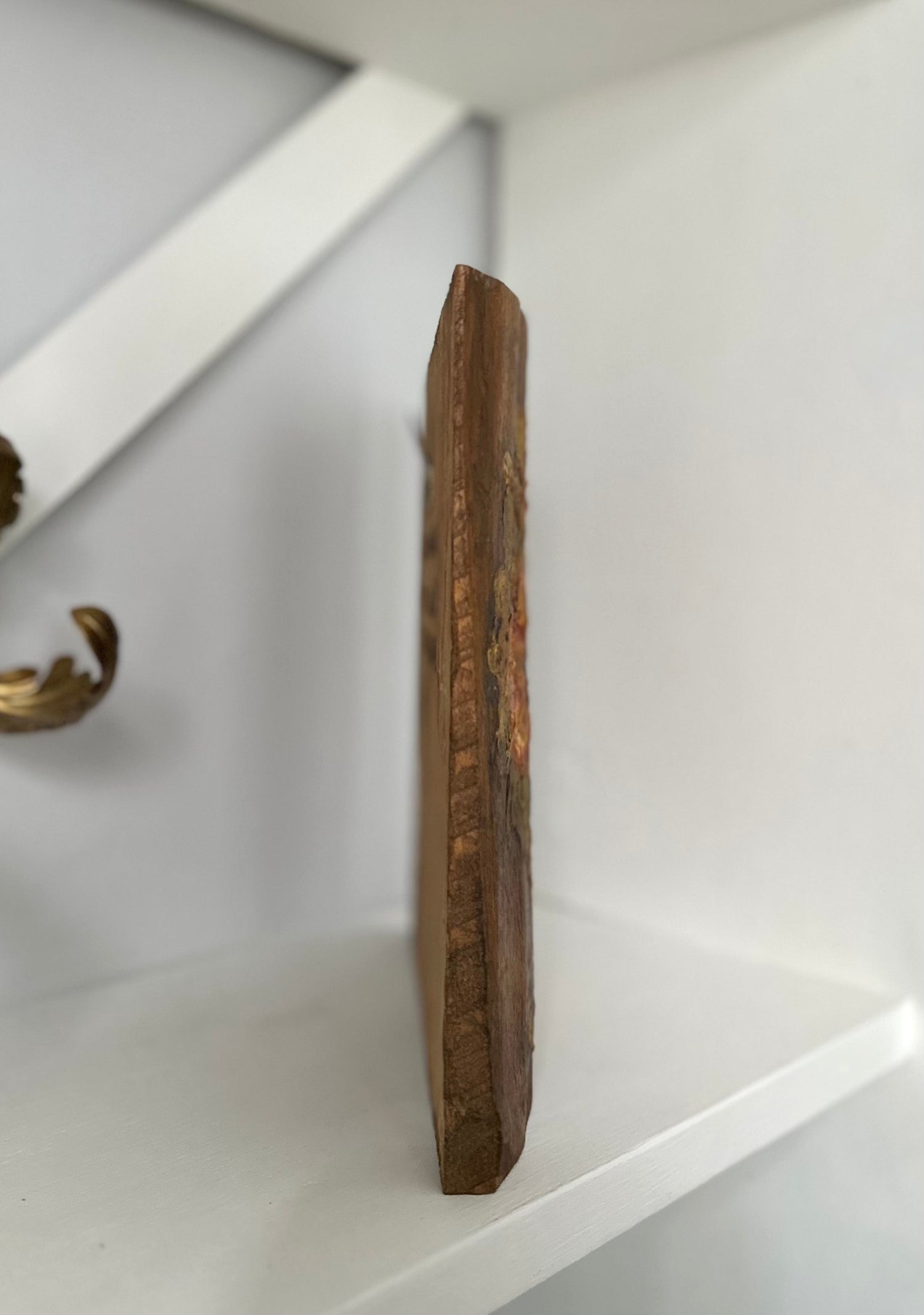 Wooden cutting board on a white shelf