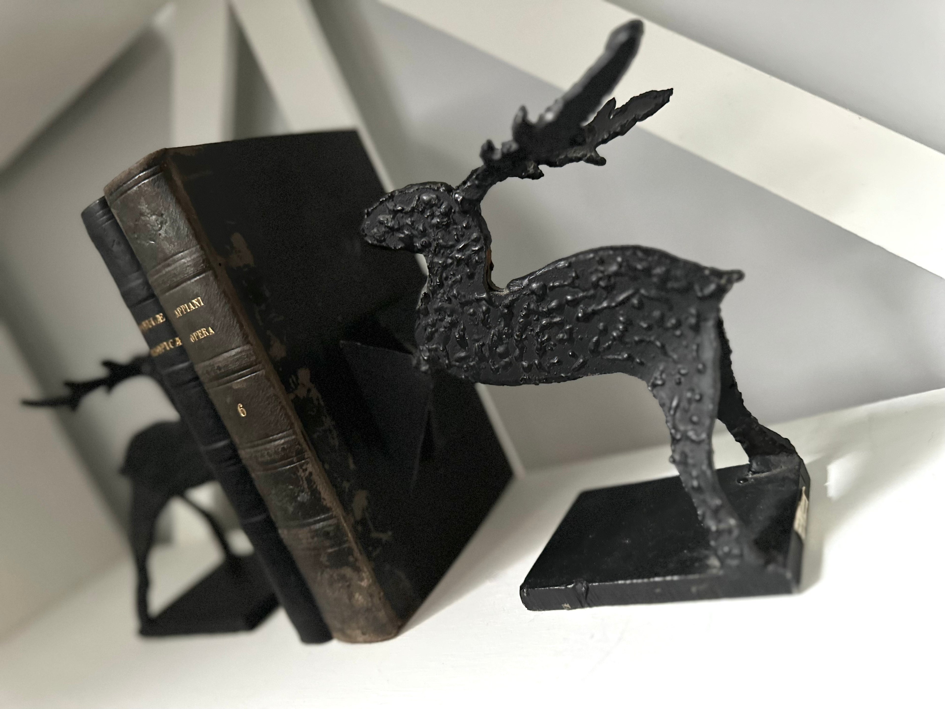Black deer-shaped bookend on a white surface