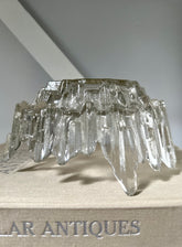 A textured bowl sitting upside down on light coloured book that says antiques