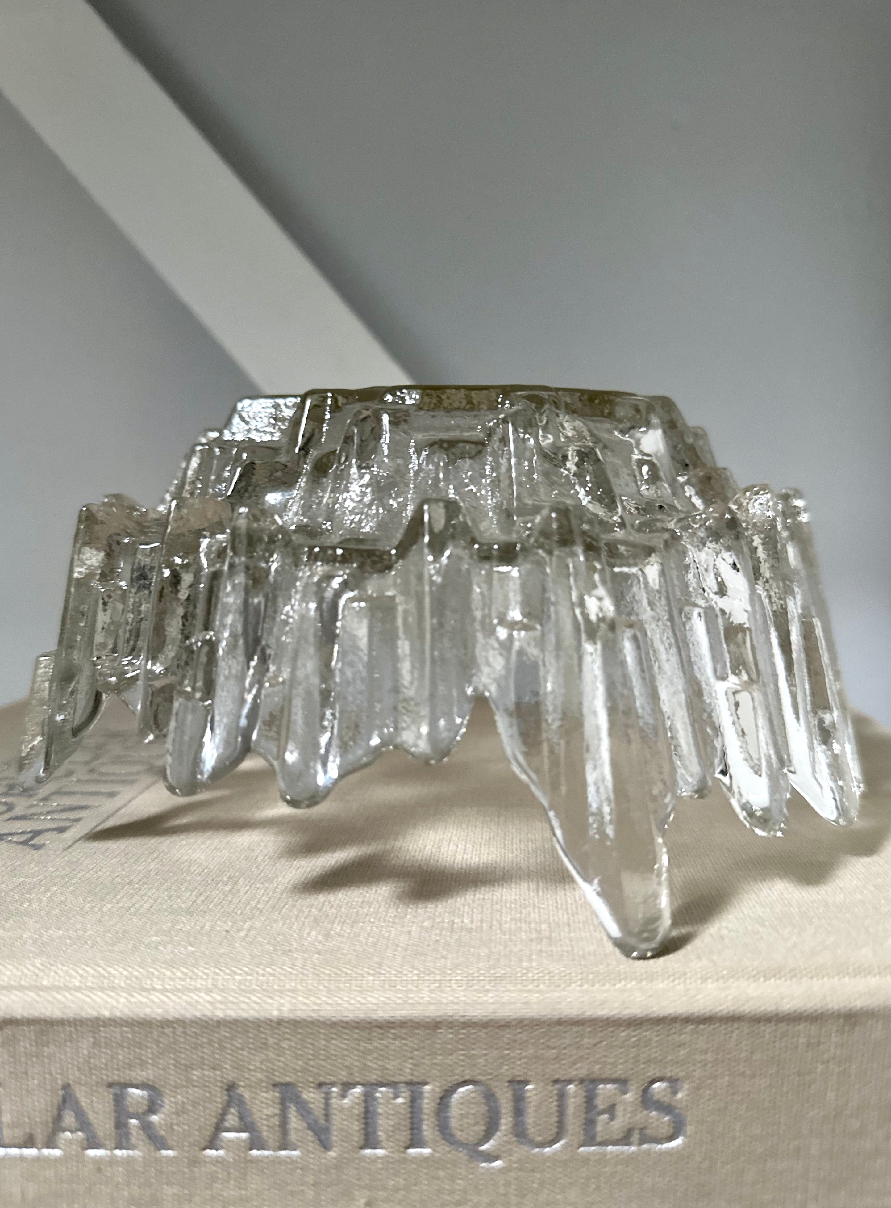 A textured bowl sitting upside down on light coloured book that says antiques