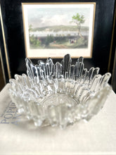 Vintage textured glass bowl sitting on a book about antiques, a black and white framed print in the background