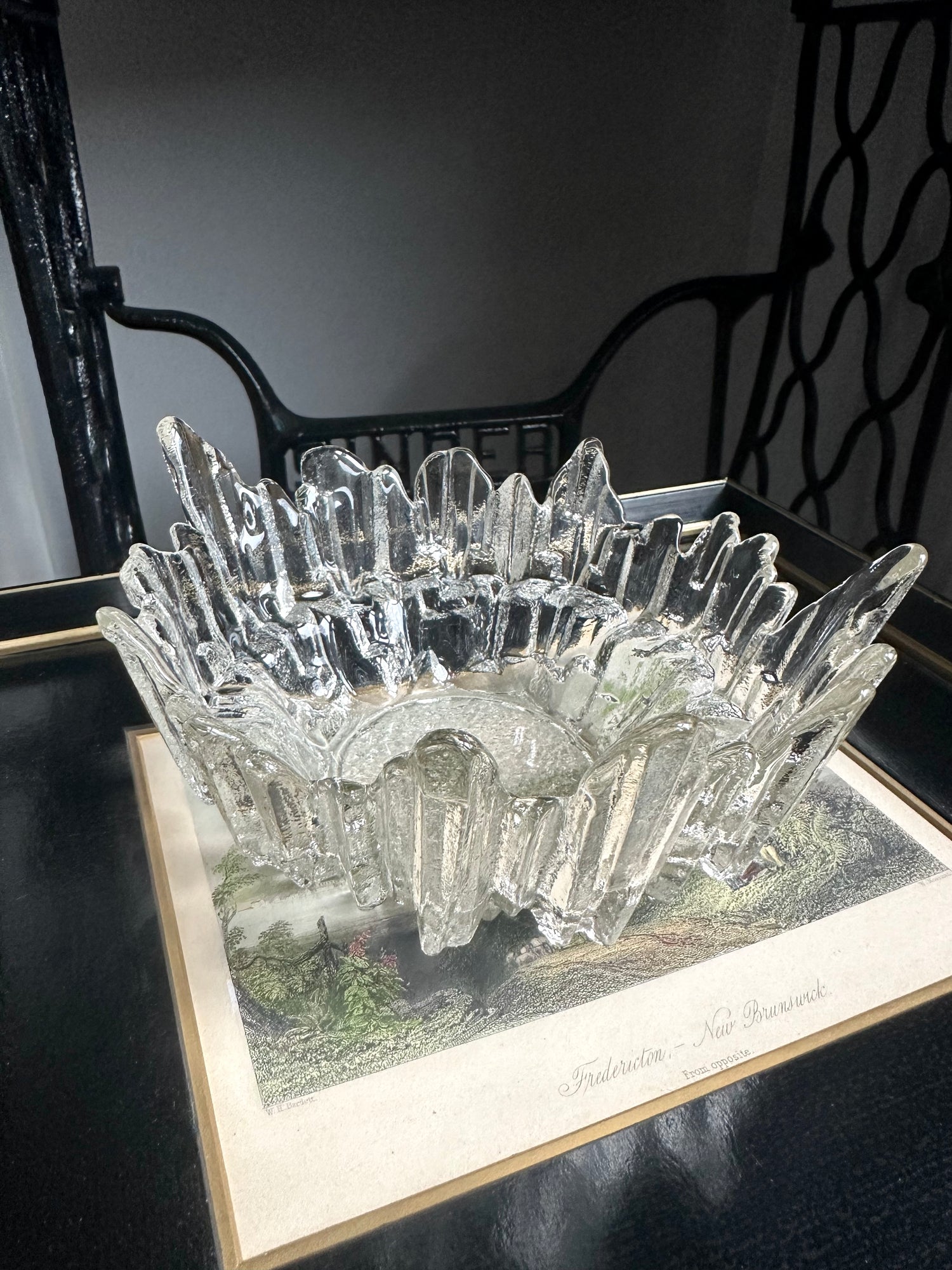 Vintage textured glass bowl sitting on a black and white print