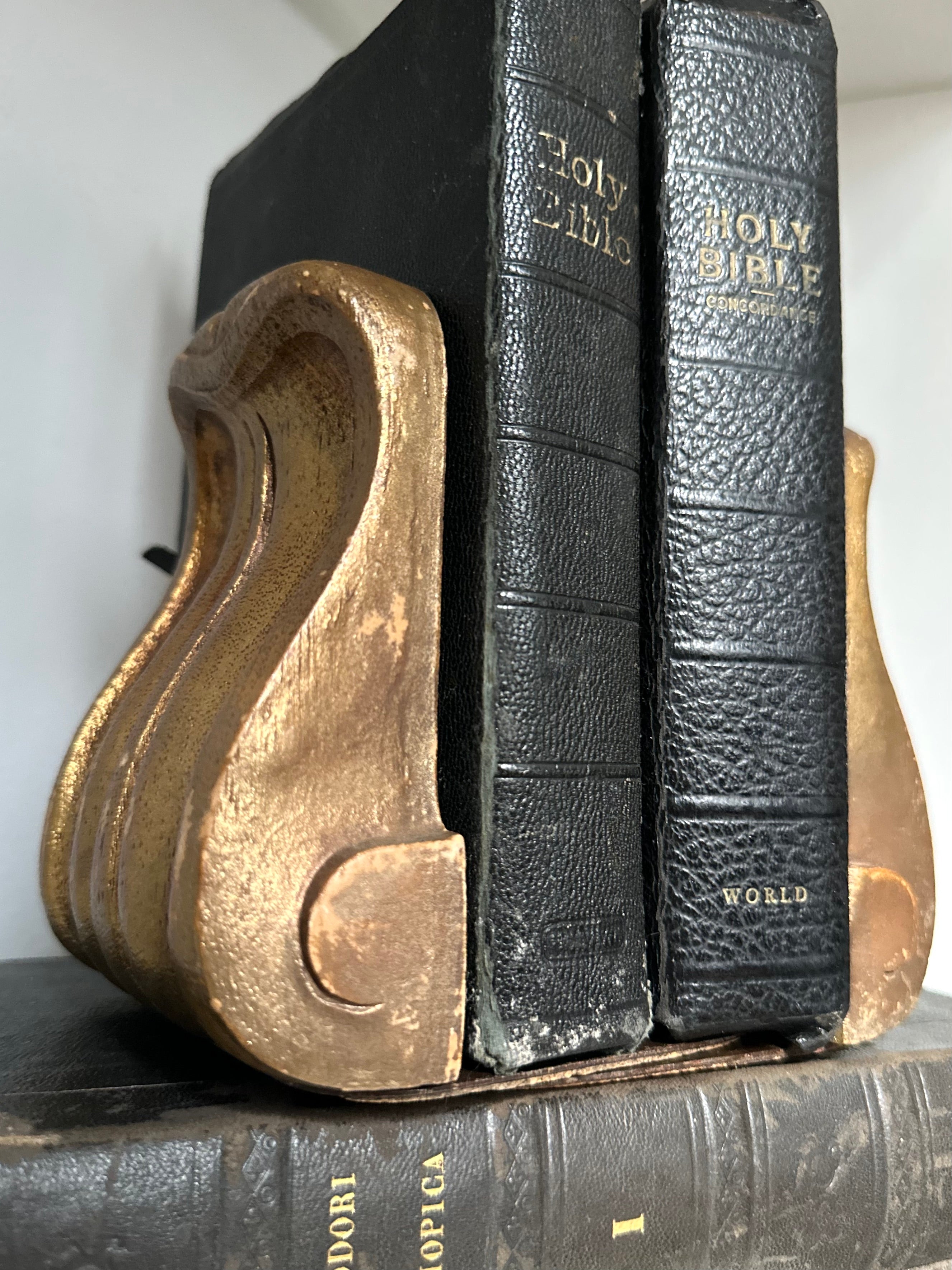 Gold bookends holding open a black leather-bound book titled &