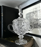 Cut Crystal Jar Sitting on Book with Vintage Print Hung Behind