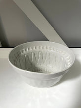 White ceramic bowl with textured design on a white surface