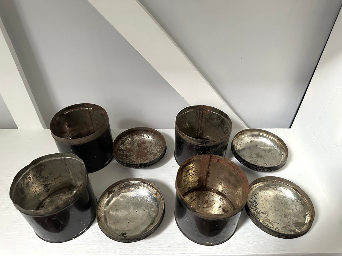 Set of metallic cups and saucers on a white surface with a light gray background