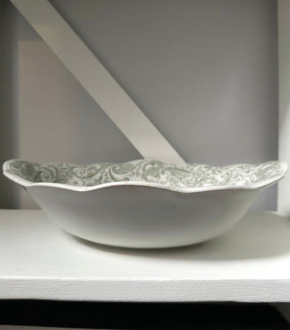 Decorative ceramic bowl with green pattern on a white surface