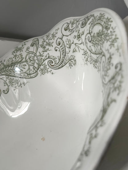 Decorative white dish with green floral patterns on a plain background