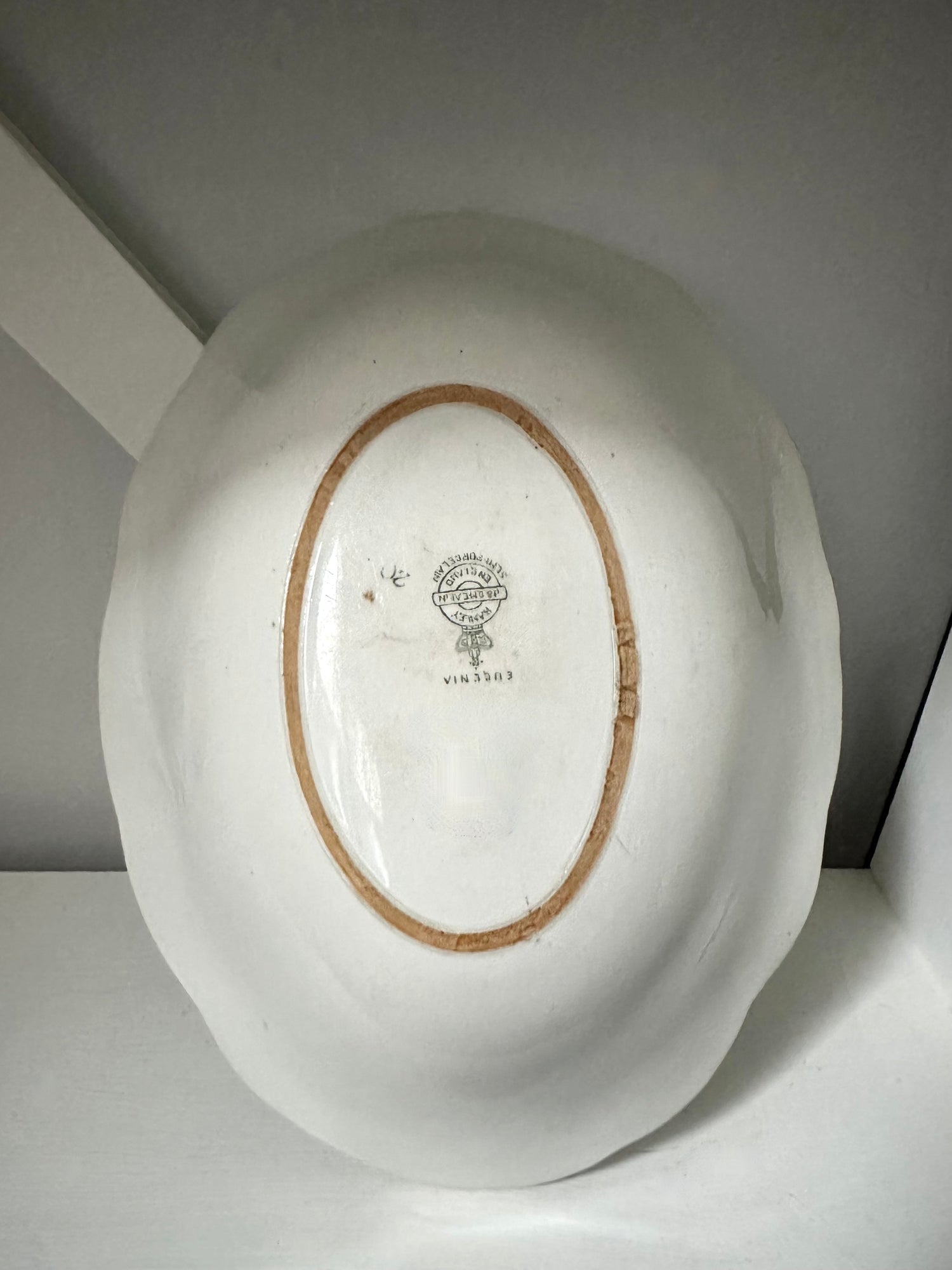 White ceramic plate with a brown rim on a white surface