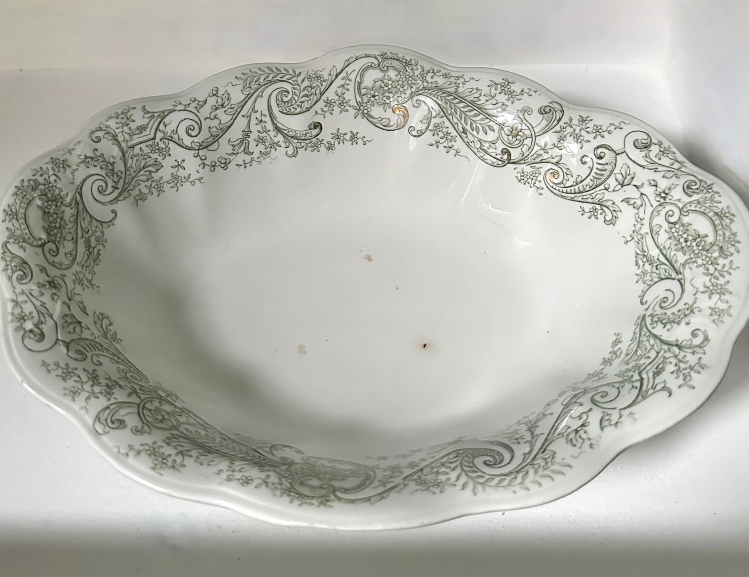 Decorative ceramic platter with intricate green patterns on a white background