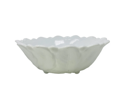 White ceramic bowl with scalloped edge on a white background
