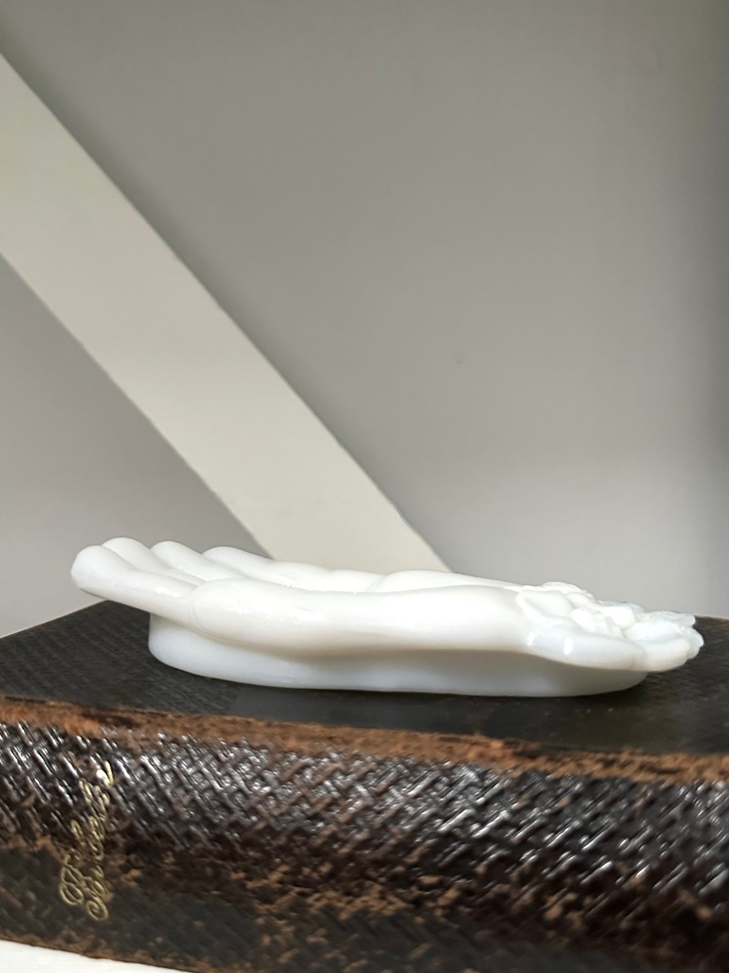 White decorative object on a textured surface with a neutral background