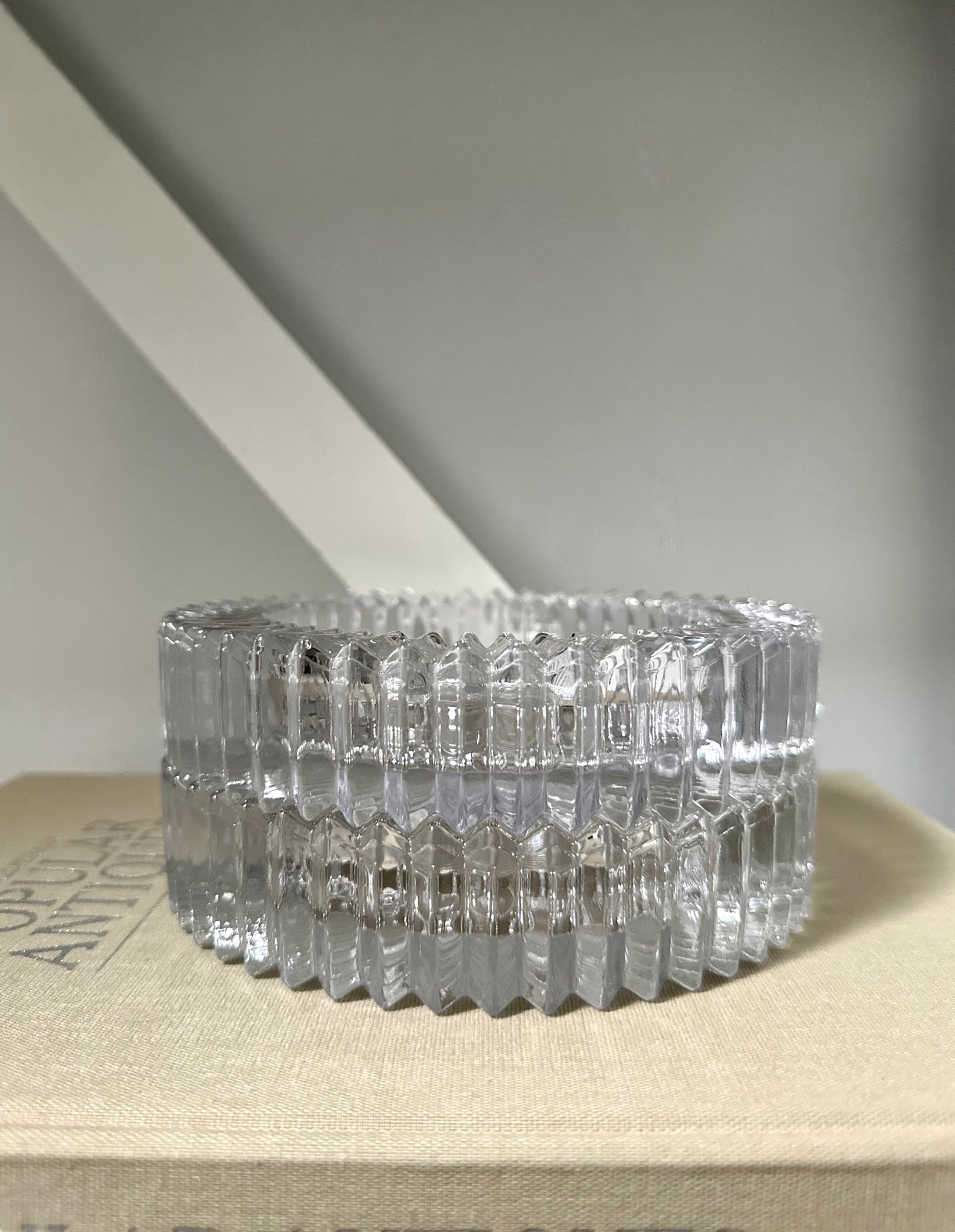 Two glass round ashtray objects sitting on a book with light background 