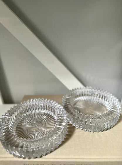 Two glass round ashtray objects sitting on a book with a light background