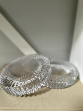 Two glass round ashtray objects sitting on a book with light background 