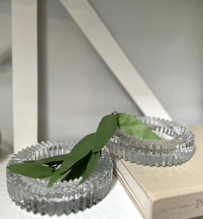 Two glass round ashtray objects sitting on a book with light background 