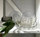 Multiple glass round bowls sitting on white shelf