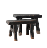 Two wooden stools with a worn black finish on a white background