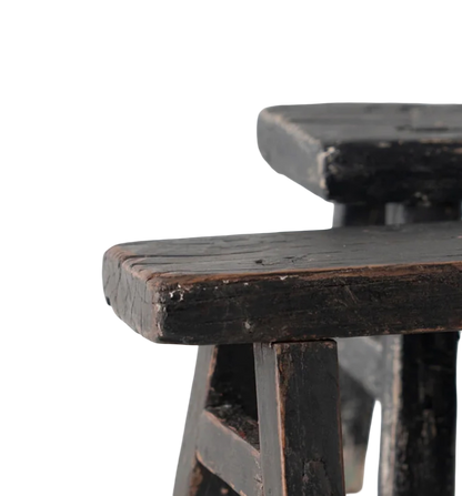 Close-up of a dark wooden stool with a white background