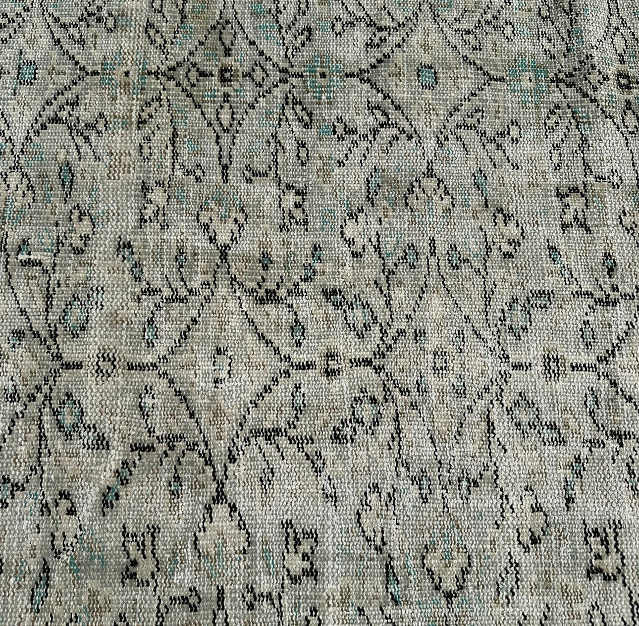 Textured fabric with intricate black pattern on a gray background