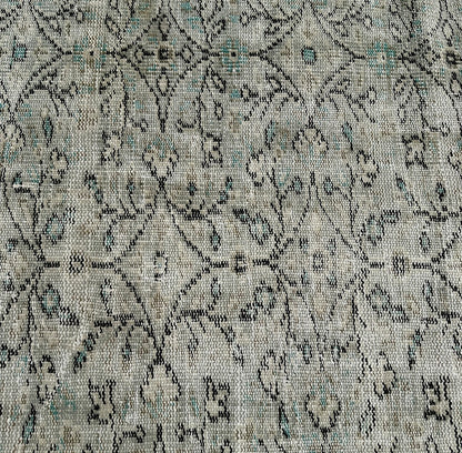 Textured fabric with intricate black pattern on a gray background