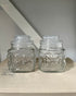 Two glass vintage jars on a linen book with neutral background