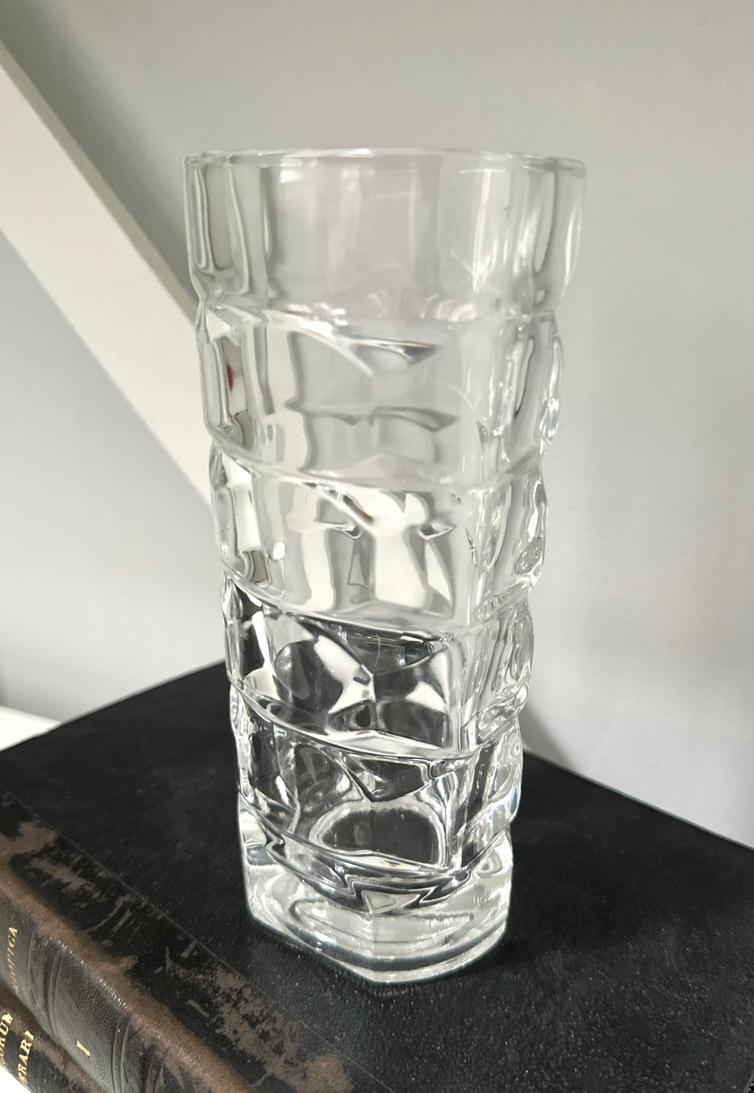 Clear glass vase with textured design on a dark surface
