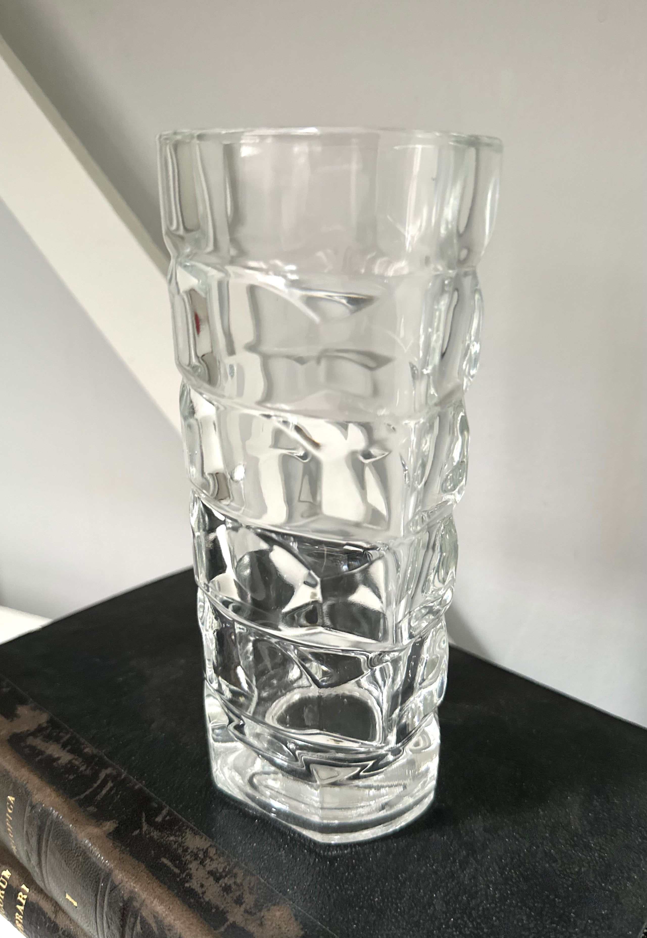 Clear glass vase with textured design on a dark surface