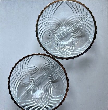 2 clear crystal bowls with metallic rim on white surface