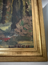 Close-up of a painting with a gold frame on a gray wall.
