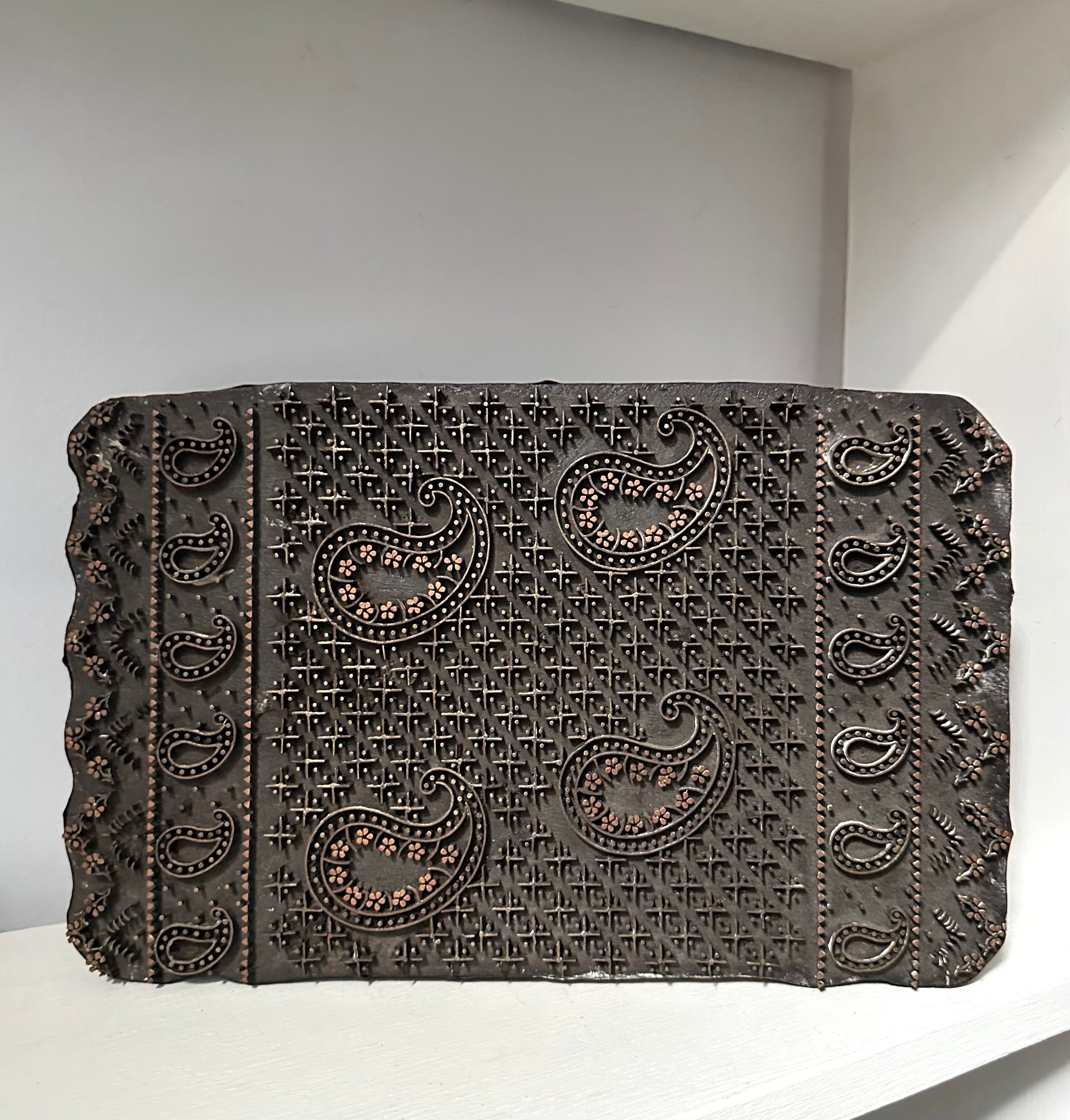 Decorative stone with paisley patterns on a white surface