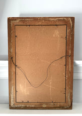 Back of a wooden picture frame with cardboard backing