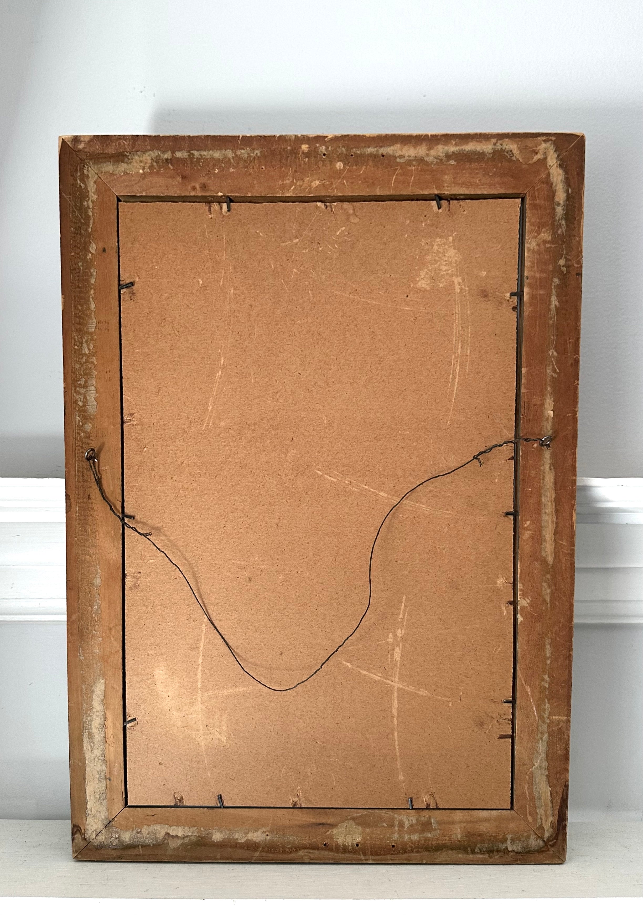 Back of a wooden picture frame with cardboard backing