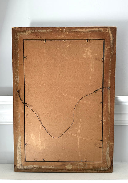 Back of a wooden picture frame with cardboard backing