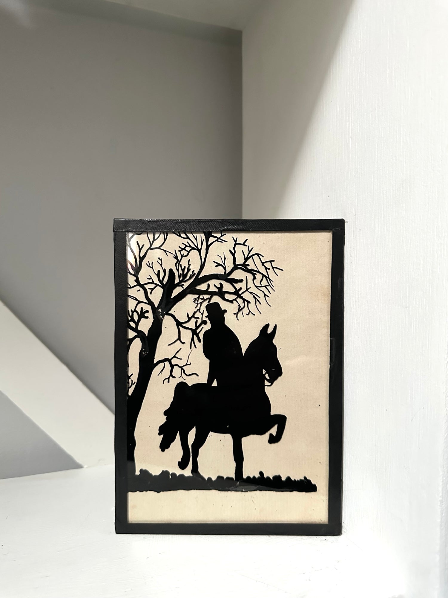 Framed silhouette art of a person on a horse under a tree