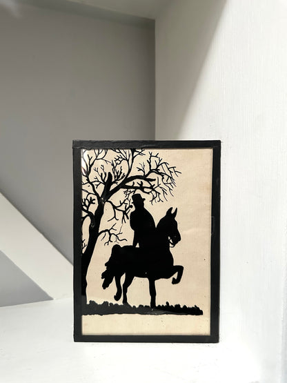 Framed silhouette art of a person on a horse under a tree