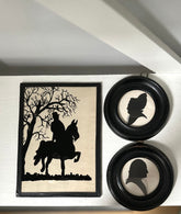 Framed silhouette art of a person on horseback and two circular silhouette portraits.