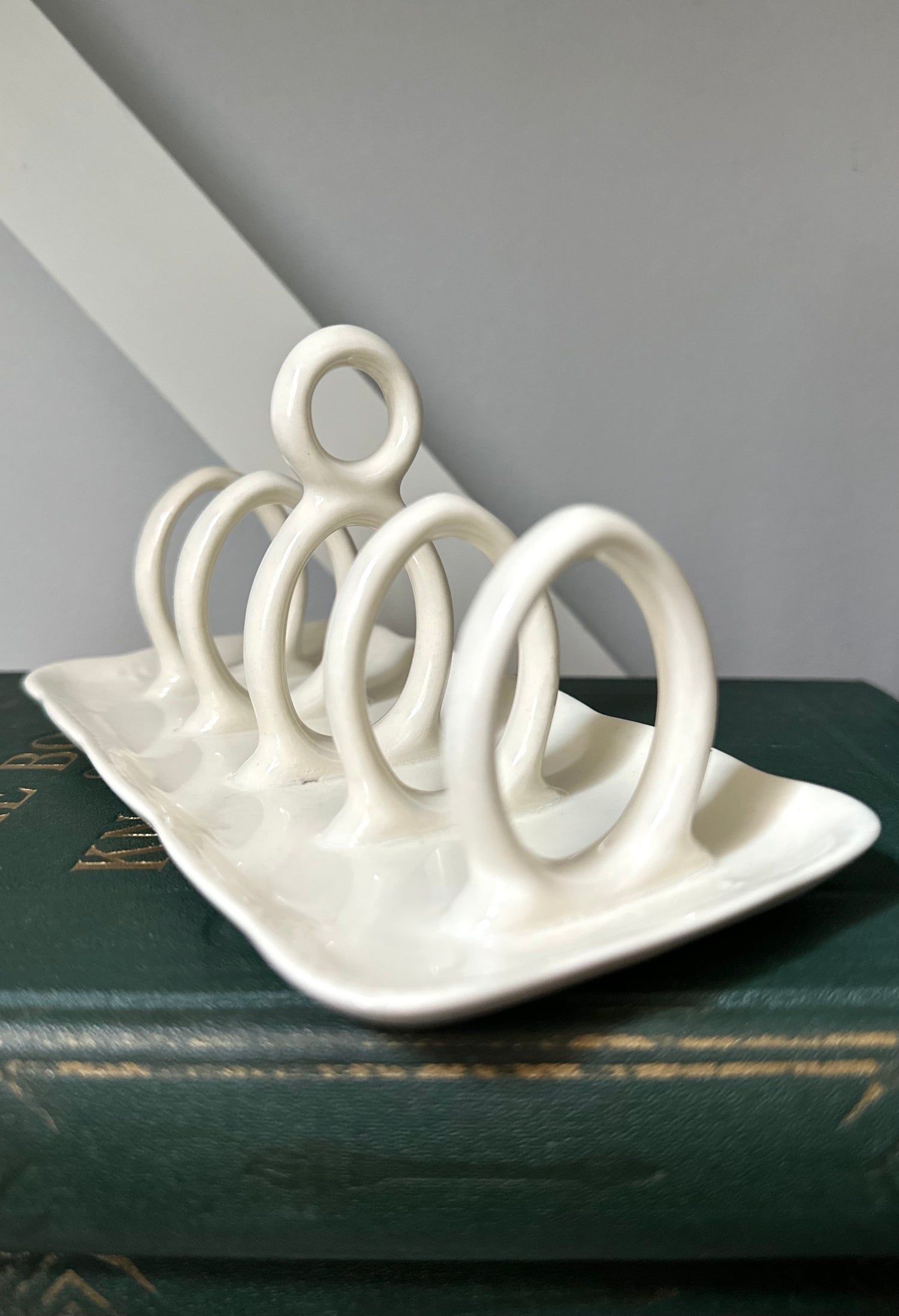 White ceramic toast rack on a dark surface with a gray background