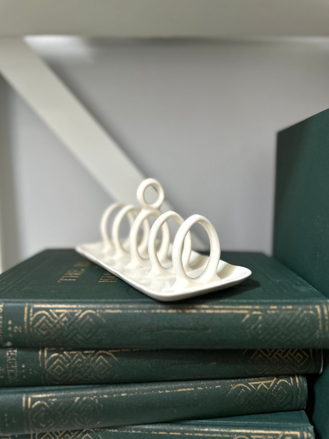 White metal ring holder on a stack of green books