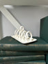 White metal ring holder on a stack of green books