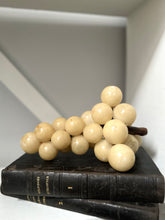 Decorative arrangement of white spherical objects on a black book with a neutral background