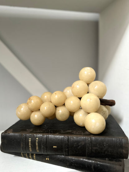 Decorative arrangement of white spherical objects on a black book with a neutral background