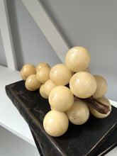 Decorative arrangement of beige spherical beads on a dark surface with a neutral background