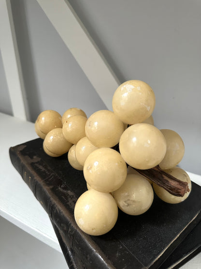 Decorative arrangement of beige spherical beads on a dark surface with a neutral background